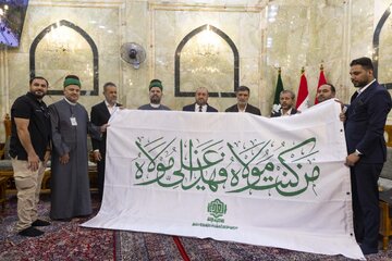 Al-Abbas Holy Shrine receives flag of glorious Eid al-Ghadir from delegation of Imam Ali Holy Shrine (+Photos)