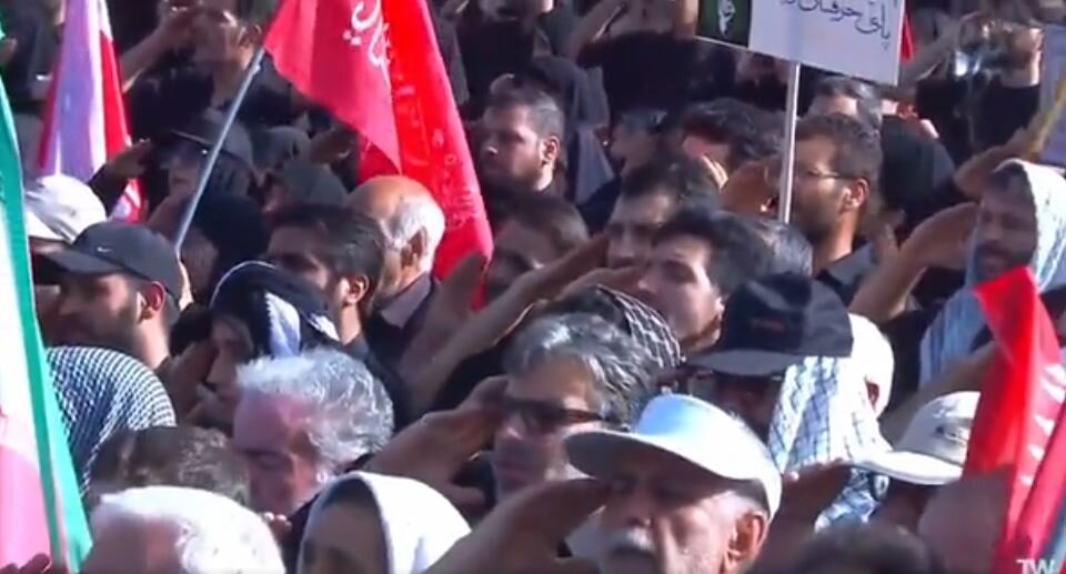 Video: People at Tehran Mosalla recite national anthem with a military salute